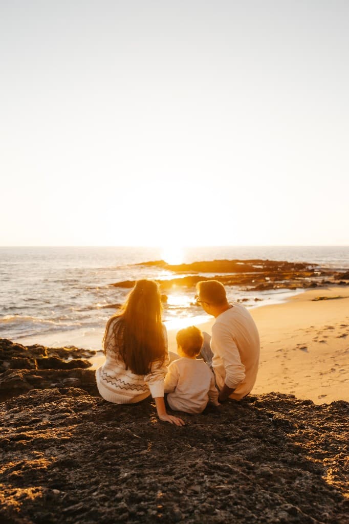 Family watching sunset on the beach